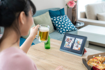 Asian woman virtual happy hour meeting party and drinking alcohol beer online together with her...