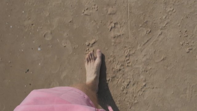 slow point of view motion video of the legs and foots of a young men walking on the sand and water of the beach of Solanas, Maldonado, Punta del Este