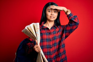 Young beautiful chinese tourist woman holding city map over isolated red background stressed with hand on head, shocked with shame and surprise face, angry and frustrated. Fear and upset for mistake.