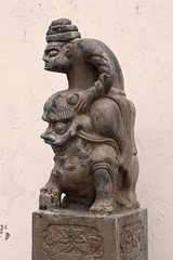 Fototapeta na wymiar Stone pillar sculpture of ancient Chinese figures riding Lions