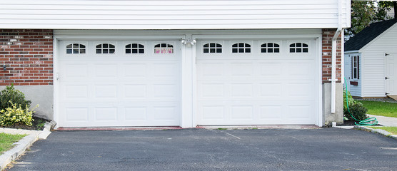 Fototapeta na wymiar Two car Garage with door painted in white, small windows 