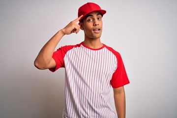 Young handsome african american sportsman wearing striped baseball t-shirt and cap Smiling pointing to head with one finger, great idea or thought, good memory