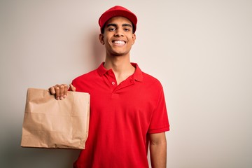 Young handsome african american delivery man holding paper bag with takeaway food with a happy face standing and smiling with a confident smile showing teeth