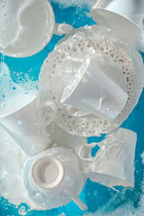 Doing dishes concept, soaked porcelain plates and cups with water ripples