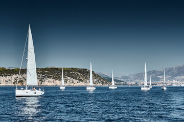 Beautiful sea landscape with sailboats, the race of sailboats on the horizon, a regatta, a Intense competition, bright colors, island with windmills are on background