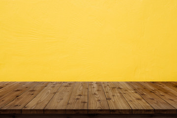Wooden table top on yellow wall background.