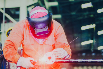 The man welding closeup by tig gas argon, Industrial Worker laborer at the factory welding steel...