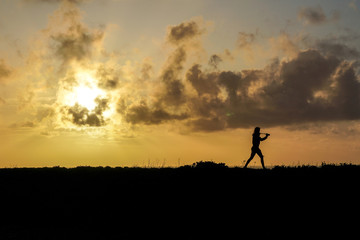 Fototapeta na wymiar Photographer silouete walking at sunset