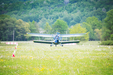 Old retro plane taking off from the small mountain airport.