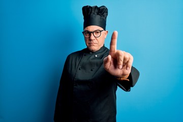 Middle age handsome grey-haired chef man wearing cooker uniform and hat Pointing with finger up and...