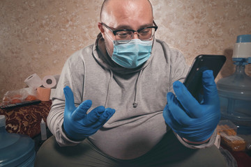 Masked man speaks very emotionally via video calling on smartphone, stress and panic from...
