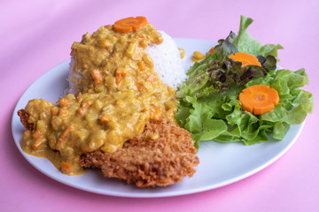 Curry fried Batter Fish with rice on plate over pink background. Top view, flat lay.