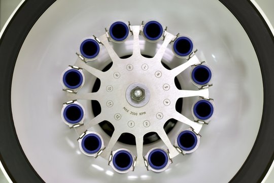 Laboratory open centrifuge with empty test tube compartments. View from above.