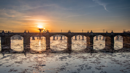 Winter sunrise through the arches of a railroad bridge over an ice-filled Susquehanna River