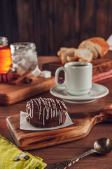 Honey cookie chocolate covered on the wooden table with coffee - pão de mel