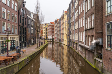 Fototapeta na wymiar Typical famous water canal and dancing houses in empty Amsterdam downtown without people due to Coronavirus Covid-19, Netherlands.