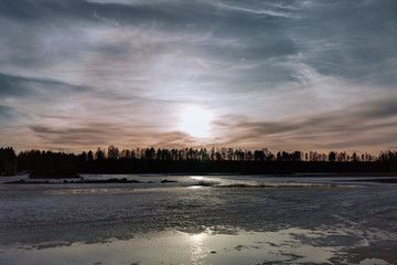 Obraz premium gloomy spring sky over a frozen river