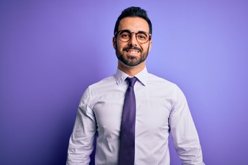 Handsome businessman with beard wearing casual tie and glasses over purple background with a happy and cool smile on face. Lucky person.
