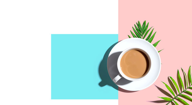 A cup of coffee with tropical leaves - flat lay