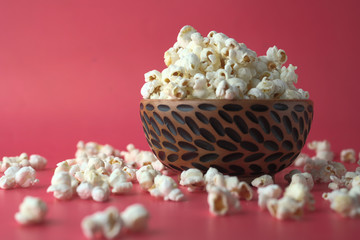 close up of popcorn in bowl on red background 