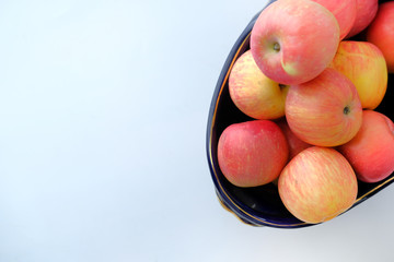 high angle view of apples in a bowl on white background.
