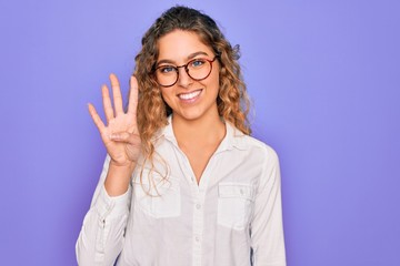 Young beautiful woman with blue eyes wearing casual shirt and glasses over purple background showing and pointing up with fingers number four while smiling confident and happy.