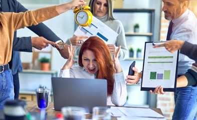 Obraz premium Group of business workers working together. Partners stressing one of them at the office