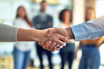 Group of business workers standing together shaking hands at the office