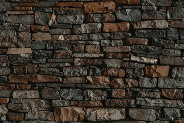 wall decorated with natural stone. Home decor with natural stone. background texture of natural stone. wall of a mountain chalet decorated with natural stone