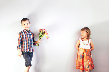 The boy gives the girl flowers.