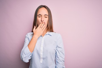 Young beautiful businesswoman wearing elegant shirt standing over isolated pink background bored yawning tired covering mouth with hand. Restless and sleepiness.