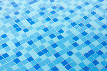 Ripple Water in swimming pool with blue tile floor background