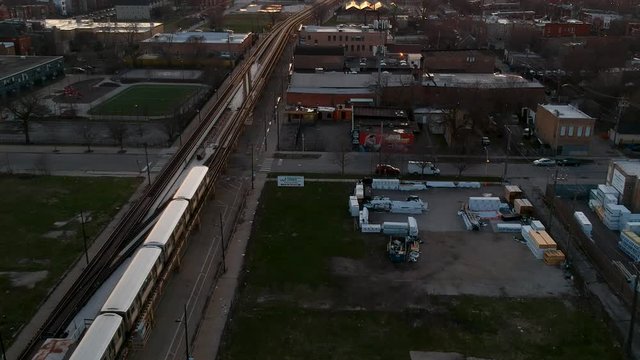 drone footage of an urban community near downtown Chicago during sunset over by the CTA Train stop. a complete view of the Chicago skyline and orange red clouds