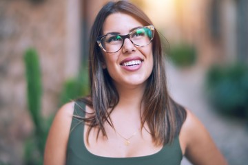 Young beautiful woman smiling happy and confident. Standing with smile on face at the town street
