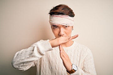 Young handsome chinese man injured for accident wearing bandage and strips on head Doing time out...