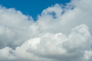 a huge cluster of fluffy cloudy under clear blue sky after rain