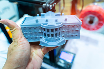 hand with builds a house closeup object printed 3d printer close-up. Progressive modern additive technology 4.0 industrial revolution