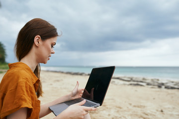 woman with laptop on the beach