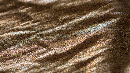 rich metallic gold foiled fabric background with shinny reflective cracked surface