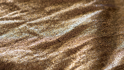 rich metallic gold foiled fabric background with shinny reflective cracked surface