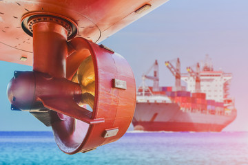Low angle view propeller in rope guard with rudder at stern ship in shipyard on cargo container ship sailing in the sea background. © TawanSaklay
