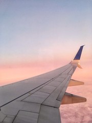 Vista del cielo rosado desde la ventana de un avión