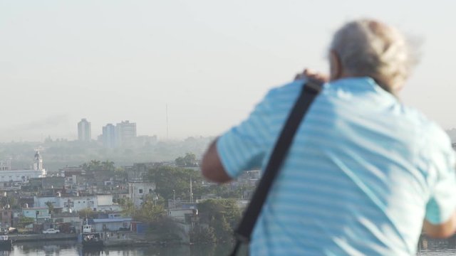 A man is taking pictures from the skyline of Havana, Cuba close up art life