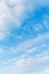 Bright blue sky in the clouds on a sunny day. Space for text. Background. Vertical.