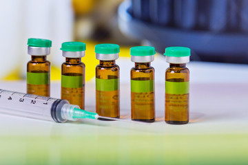 syringe and vials of injectable drugs - green
