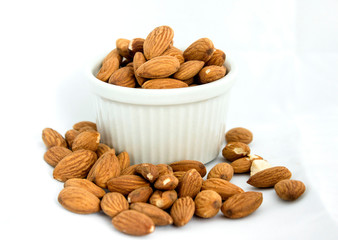 Taza blanca con nueces en un fondo blanco