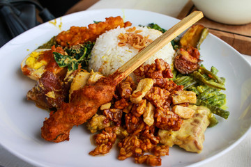 Indonesian, Balinese traditional food, spicy Pork Satay with fried soybean, Tempeh,white rice, and vegetables.