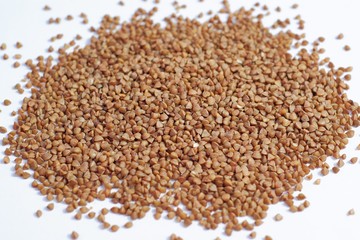Buckwheat scattered grits on a white background.