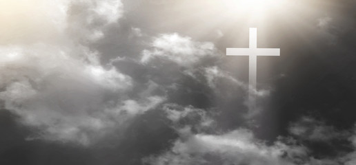 The Christian cross looks bright in the sky, white, black, gray, with soft white clouds and beautiful light shining, leading to peace and heaven