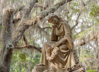 Fototapeta na wymiar Statue of Woman Under Moss Laden Live Oak Tree , Boneventure Cemetery, Thunderbolt, Georgia, USA
